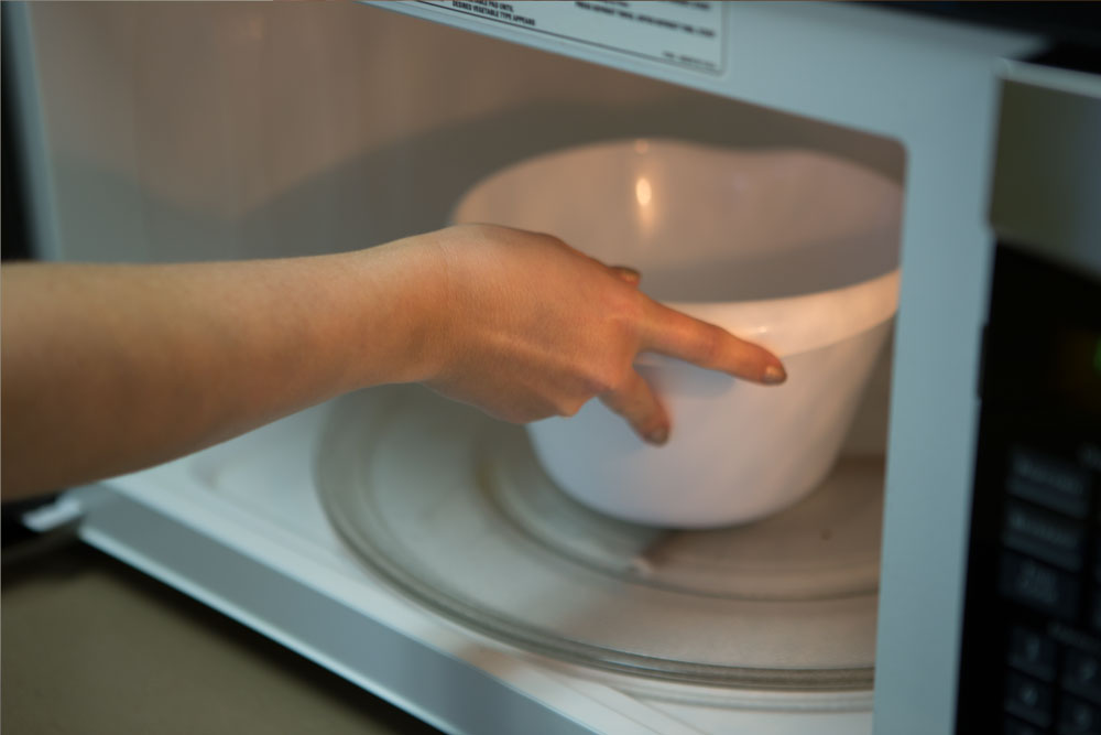 Placing bowl in the microwave.