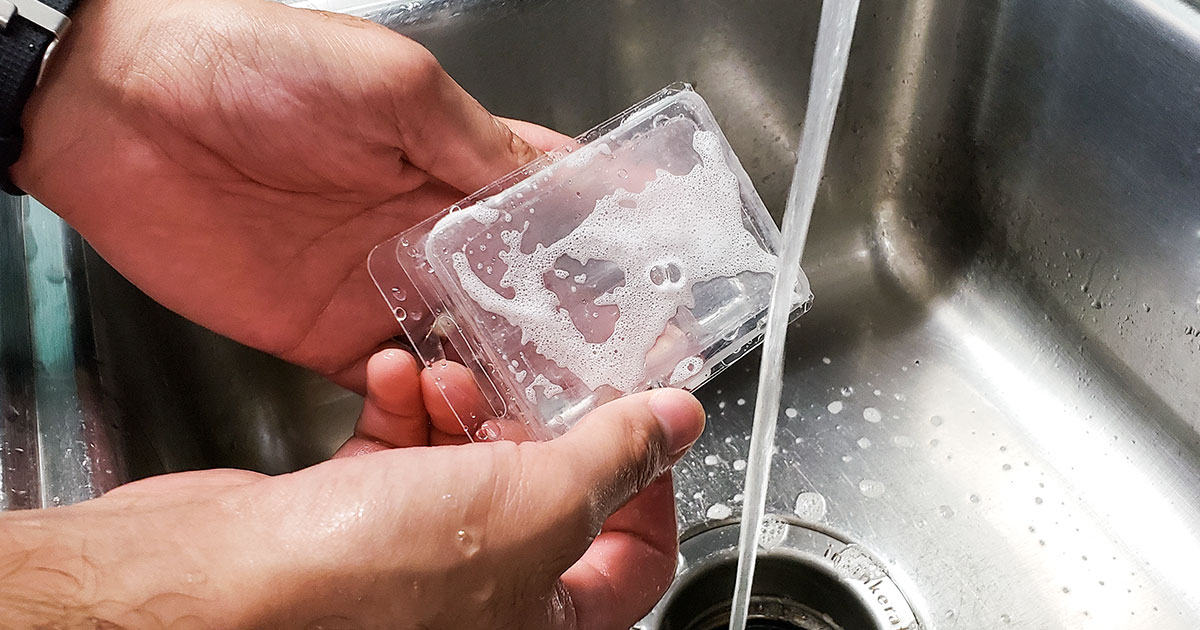 Washing a plastic container with soap and water.